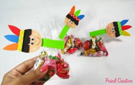 Brindes de festa com personagens indígenas feitos de papel e doces.