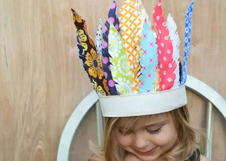 Criança usando uma coroa colorida feita de papel.
